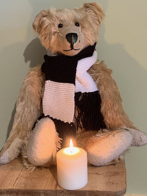 Bertie, wearing his Fulham scarf, sat behind a candle lit for Diddley and Tosh Chamberlain.